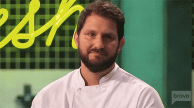 A Man With A Beard Is Wearing A White Chef 'S Jacket With The Word Bravo On The Front GIF