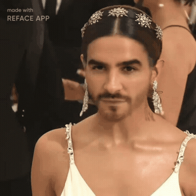 A Man With A Beard Is Wearing A White Dress And Earrings Made By Reface App GIF