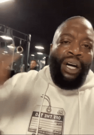 A Man With A Beard Is Wearing A White Hoodie With A Tag That Says Dt 3Ht 370 On It GIF