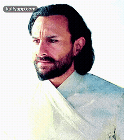 A Man With A Beard Is Wearing A White Shirt And A White Cloth Around His Neck GIF