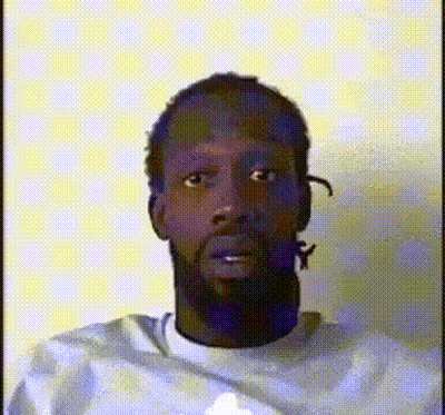 A Man With A Beard Is Wearing A White Shirt And Making A Funny Face GIF