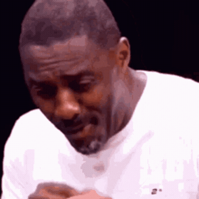 A Man With A Beard Is Wearing A White Shirt . GIF