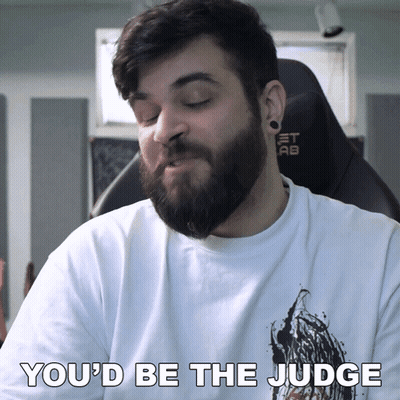 A Man With A Beard Is Wearing A White Shirt That Says " You 'D Be The Judge " GIF