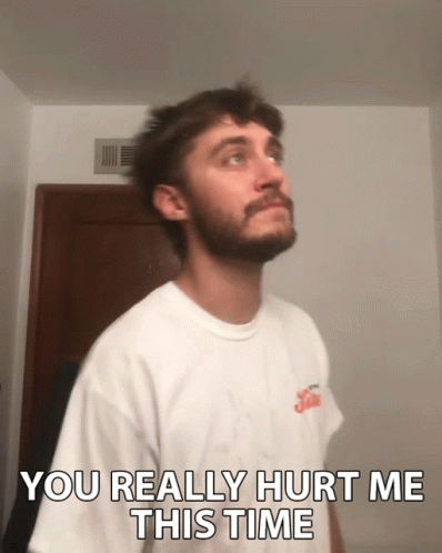 A Man With A Beard Is Wearing A White Shirt That Says ' You Really Hurt Me This Time ' GIF