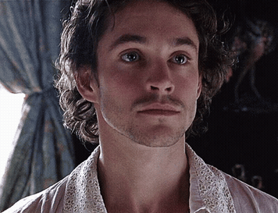 A Man With A Beard Is Wearing A White Shirt With A Lace Collar GIF