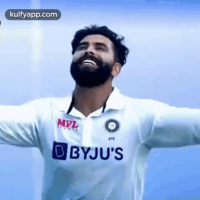 A Man With A Beard Is Wearing A White Shirt With Bbyju 'S Written On It . GIF