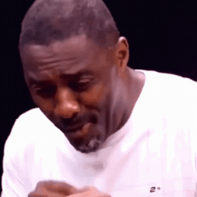 A Man With A Beard Is Wearing A White T-Shirt And Making A Funny Face . GIF