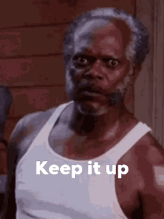 A Man With A Beard Is Wearing A White Tank Top And Has The Words `` Keep It Up '' Written On It . GIF