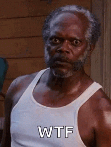 A Man With A Beard Is Wearing A White Tank Top . GIF