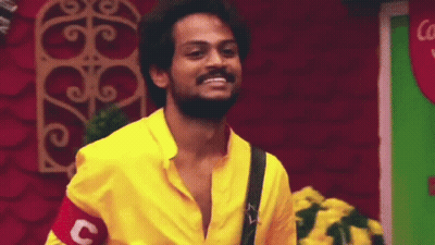 A Man With A Beard Is Wearing A Yellow Shirt And Smiling . GIF
