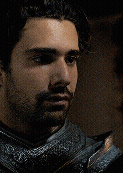 A Man With A Beard Is Wearing Armor And Looking At Something GIF