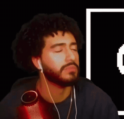 A Man With A Beard Is Wearing Ear Buds And A Microphone GIF