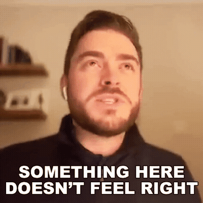A Man With A Beard Is Wearing Ear Buds And Saying Something Here Does N't Feel Right . GIF