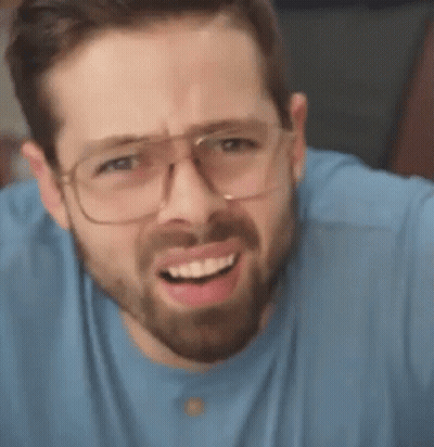 A Man With A Beard Is Wearing Glasses And Making A Funny Face . GIF