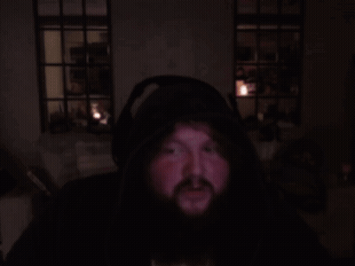 A Man With A Beard Is Wearing Headphones And A Hoodie GIF