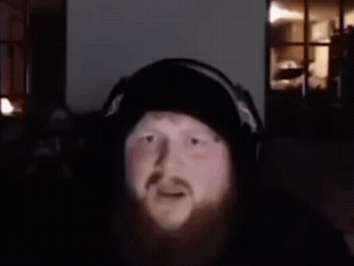 A Man With A Beard Is Wearing Headphones And Has The Words What Is That Supposed To Mean Above Him GIF