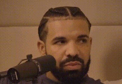 A Man With A Beard Is Wearing Headphones And Looking At The Camera . GIF