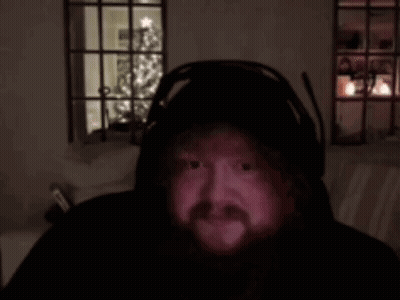 A Man With A Beard Is Wearing Headphones And Looking At The Camera . GIF