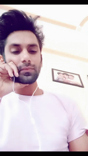 A Man With A Beard Is Wearing Headphones And Looking Down GIF
