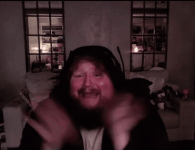 a man with a beard is wearing headphones and making a face