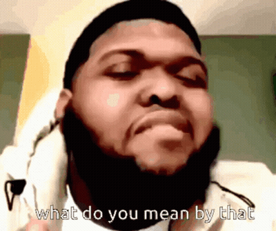 A Man With A Beard Is Wearing Headphones And Says " What Do You Mean By That " GIF