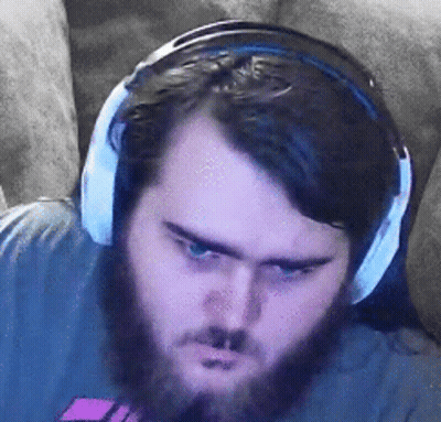 A Man With A Beard Is Wearing Headphones While Sitting On A Couch . GIF