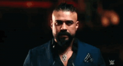 A Man With A Beard Is Wearing Sunglasses And A Ring And The Word Andrade Is Behind Him GIF