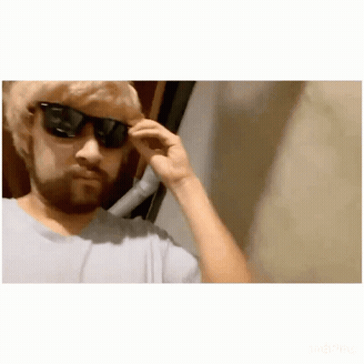 A Man With A Beard Is Wearing Sunglasses And Adjusting His Glasses . GIF