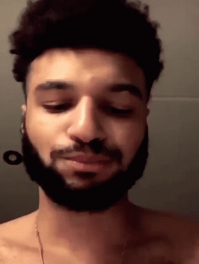 A Man With A Beard Is Without A Shirt And Is Looking Down . GIF