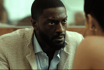 A Man With A Beard Looks At A Woman With A Serious Look On His Face GIF