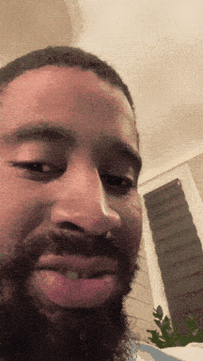 A Man With A Beard Looks At The Camera GIF
