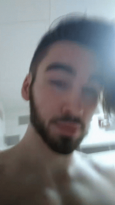 A Man With A Beard Looks At The Camera GIF