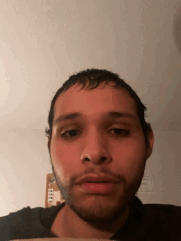A Man With A Beard Looks At The Camera With A Serious Look On His Face GIF