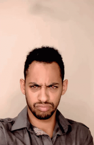 A Man With A Beard Makes A Funny Face With His Eyes Closed GIF