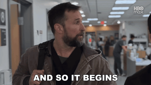 A Man With A Beard Says " And So It Begins " In A Hallway GIF