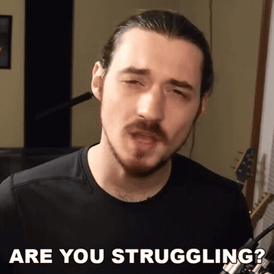 A Man With A Beard Says " Are You Struggling " In Front Of A Microphone GIF