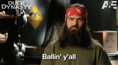 A Man With A Beard Says Ballin ' Y 'All In Front Of A Sign That Says Duck Dynasty GIF