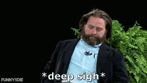 A Man With A Beard Says " Deep Sigh " In Front Of Some Ferns GIF
