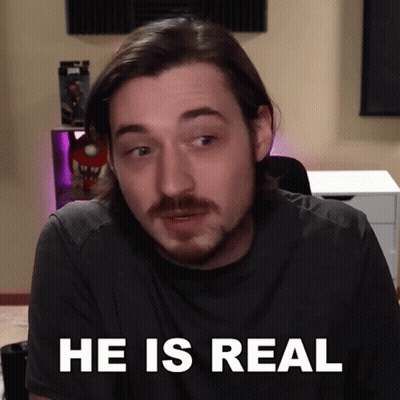 A Man With A Beard Says He Is Real In Front Of A Desk GIF