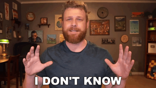 A Man With A Beard Says " I Don 'T Know " In Front Of A Wall Of Pictures GIF