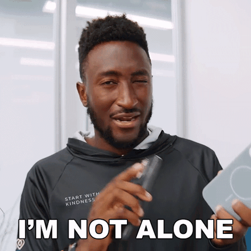 A Man With A Beard Says I 'M Not Alone While Holding Something GIF