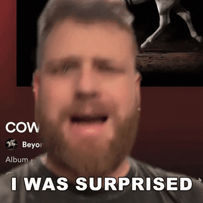 A Man With A Beard Says " I Was Surprised " In Front Of A Picture Of A Cow GIF