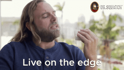 A Man With A Beard Says " Live On The Edge " In Front Of A Dr.squatch Logo GIF