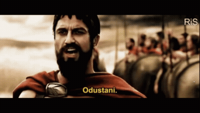 A Man With A Beard Says " Odustani " In Front Of A Crowd GIF