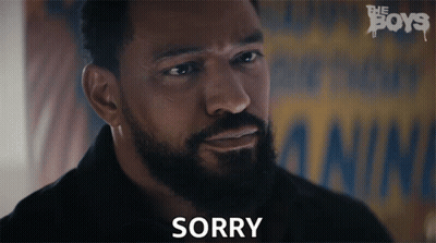 A Man With A Beard Says Sorry In Front Of A Poster For The Boys GIF
