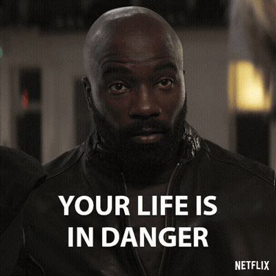 A Man With A Beard Says Your Life Is In Danger On A Netflix Poster GIF
