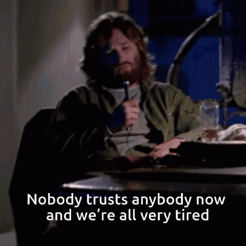 A Man With A Beard Sits At A Table With The Words Nobody Trusts Anybody Now GIF