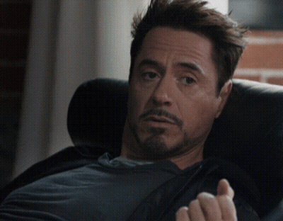 A Man With A Beard Sits In A Chair With His Hand Out GIF