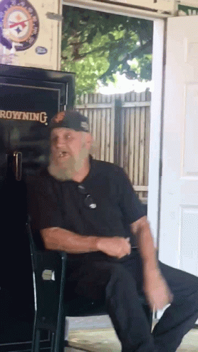 A Man With A Beard Sits In Front Of A Browning Safe GIF