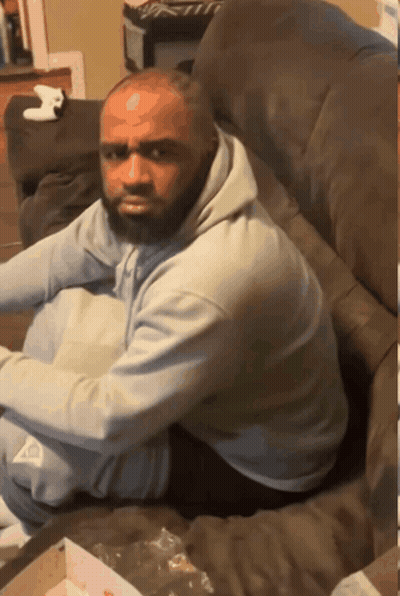 A Man With A Beard Sits On A Couch GIF
